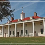 historic colonial-style house with a large porch and green lawn