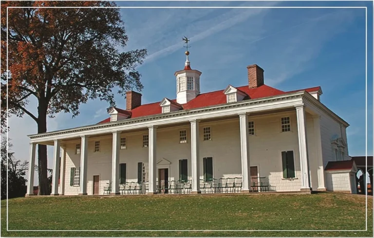 historic colonial-style house with a large porch and green lawn